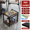 Ao lado da Mesa de Mahjong na Sala de Jogos, Há uma Pequena Mesa Lateral, um Estante de Armazenamento, um Carrinho Móvel para Chá e Água, um Armário Lateral e um Cinzeiro.