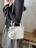 Bolso de mano de color liso con diseño único, bolso tipo cubo de moda, versión coreana ins dulce moderno para hombro y cruzado para mujer