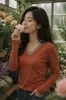 Suministrado directamente por la fábrica de ropa de origen, top versátil de retazos para mujer de talla grande de otoño con manga larga y cuello en V, disponible para pedidos personalizados con sus propios diseños o muestras.