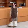 Conjunto de Otoño Estilo Coreano para Niñas 2026 Nuevo Modelo: Conjunto de Tres Piezas para Niños (Tallas Mediana y Grande): Camiseta Básica, Chaleco, Falda a Cuadros y Pantalones de Pierna Ancha