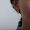Europa y Estados Unidos aretes de acero de titanio de caja compacta exquisita única transfronteriza diseño de mini personalidad chapado que no se desvanece aretes de 18 quilates