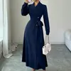 Moda Transfronteriza Europea y Americana para Mujer Otoño e Invierno 2026 Abrigo Largo Estilo Traje con Cuello Solapa, Mangas Largas, Cinturón en la Cintura y Largo Extendido para Viajar al Trabajo