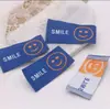 Cara sonriente de color etiqueta de tela tejida etiqueta trasera cuerda para el pelo diy banda de goma etiqueta pasador de pelo material de decoración para tocado accesorios