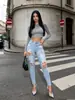 Jeans skinny azul claro lavado e rasgado estilo europeu e americano, calças lápis justas e elásticas, direto da fábrica