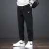 Calça Nova Masculina da Moda para Primavera e Outono Marca Tendência Solta Versátil Elástica Esportiva Jogger Calça de Moletom de Veludo Cotelê Bordada