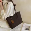 Bolso de hombro y mano de gran capacidad, elegante, sencillo y de alta gama para el día a día con colgantes, nuevo bolso de mano tote para mujer de otoño 2026