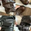Botas de plataforma em couro com solas grossas, design de perna larga e salto bloco, apresentando estilo cowboy western, salto robusto e detalhe de fivela de cinto.