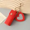 Mini llavero de lipstick portátil, bolsa redonda de cuero con espejo de maquillaje, accesorio para niñas, colgante de bolsa de espejo de maquillaje portátil