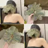 Vibras de primavera y verano con una scrunchie de hilo verde menta sirena brillante con cuentas para un peinado de coleta baja