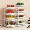 Suporte multifuncional de vários níveis para preparação e armazenamento de utensílios de cozinha, incluindo tigelas, pratos, panelas quentes, travessas e legumes.