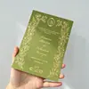 Tarjeta de invitación de boda de tela de terciopelo verde salvia con monograma floral de pan de oro y texto en español