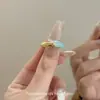 Cuando se usa el Anillo Mundial Noche Azul en las mujeres, es dulce, versátil, único, simple, de alta clase, elegante y presenta un diseño de color block de nicho.