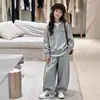 Conjunto de roupas esportivas de outono estiloso e moderno para meninas, com um moletom de duas peças falso e calças de moletom casuais em estilo coreano