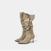 Sin embargo, estas son botas vaqueras de tacón alto de gamuza estilo retro para mujer, que llegan hasta la rodilla, con punta fina, tacón delgado y detalle de hebilla metálica.