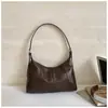 Bolso de axila coreano de nicho transfronterizo para mujer, nuevo bolso de moda tipo media luna 2026, bolso de hombro cruzado simple y versátil, moderno