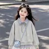 Roupa moderna para primavera e outono para meninas: um conjunto de duas peças apresentando um top listrado com gola e painéis contrastantes e uma saia de renda lisa