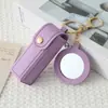 Mini llavero de lipstick portátil, bolsa redonda de cuero con espejo de maquillaje, accesorio para niñas, colgante de bolsa de espejo de maquillaje portátil