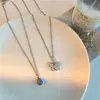 Collar con colgante geométrico de mariposa y circón en capas, estilo gota de agua azul, cadena doble con diseño de viento frío para clavícula.