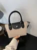 Bolso de hombro de nailon simple color block, bolso con forma de dumpling, versátil para primavera y verano, un bolso de mano de nicho y elegante con una textura de moda