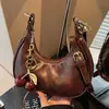 Bolso de axila para el día a día con un toque de alta gama, diseño de nicho, colgante de cereza, bolso cruzado para mujer, nuevo bolso francés de media luna 2026