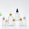 Frascos goteros de vidrio transparente para aceites esenciales, disponibles en varios tamaños, con tapas doradas y puntas de goma, ideales para almacenar y dispensar sueros y concentrados cosméticos, y para un uso conveniente en viajes