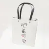 Bolso de mano blanco personalizado con cuerda negra y remaches, bolsa de regalo de papel minimalista, bolsa de papel de compras de alta gama, fábrica de impresión a color