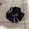 Elegante scrunchie de lunares con volantes, lazo de piel y diseño plisado para coletas