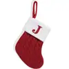 Calcetines navideños rojos exquisitos con letras, bolsas de dulces y adornos para colgar en el árbol de Navidad.