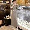 Traje falda casual de alta gama en color gris para primavera y otoño, juvenil y elegante, conjunto de dos piezas de sudadera con cuello polo y falda midi para mujer
