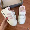 Tenis blancos para niña, nuevo estilo 2026, con diseño de Hello Kitty, cierre de velcro, estampado de huella de pata de gato, suela suave, material transpirable, puntera en forma de concha, franjas rosas y un diseño versátil
