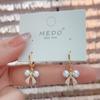 Pendientes elegantes de nicho con hebilla de oreja de perla y lazo, de moda coreana, elegantes y de diseño de celebridades de Internet, que combinan con todo.