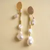 Pendientes de borla de flor de concha blanca transfronterizos europeos y americanos con perlas, pendientes de estilo de corte francés, pendientes ligeros y lujosos con un toque de alta gama
