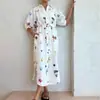 Roupas femininas transfronteiriças europeias e americanas de 2026: vestido longo confortável, de corte solto, estampado, com botões, amarração frontal e gola de lapela, perfeito para férias