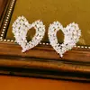 Pendientes de aguja plateada con diseño de corazón hueco incrustado con circonita, pendientes de moda de nicho únicos y elegantes, sensación de lujo ligero y alta gama, venta al por mayor