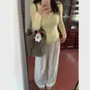Suéter de tricô amarelo claro com decote em U estilo feminino 2025 primavera/outono design único de botões estilo desejo puro blusa básica feminina de manga longa