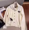 Nuevo estilo de invierno: un conjunto de dos piezas que incluye un cárdigan de punto de lana con cuello redondo y un patrón de jacquard, combinado con una bufanda, en color blanco roto