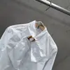 Camisa com Fivela de Metal Estilo Francês, Gola Alta, Mangas Longas, Corte Amplo, Elegante e Sofisticada, Outono/Inverno 2026, Transfronteiriça