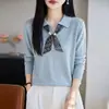 Suéter feminino de tricô fino em lã com gola de lapela, combinado com um lenço de seda, criando um visual elegante e que afina a silhueta, perfeito como uma elegante camada interna para o trabalho.