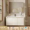 Tocador de baño engrosado y ahorrador de espacio con diseño en color crema, que cuenta con un lavabo redondeado, lavabo cerámico integrado y un lavabo de una sola pieza.