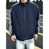 Chamarra bomber deconstruida estilo americano en color azul marino para hombre, con franjas otoñales, diseño de patchwork, cuello alto y estilo casual de chamarra de béisbol.