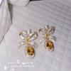 Pendientes con gemas de lazo de serpentina brillante chapados en oro de 18 quilates y flores de circón multicolor talladas.