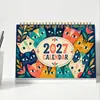 Suministro directo transfronterizo de calendarios de escritorio en inglés 2027 con 12 diseños de ilustraciones mensuales diferentes