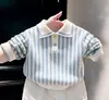 Conjunto Estilo Académico para Niños Estilo Coreano Primavera y Otoño 2026 Nuevo Suéter de Punto Rayado Azul Pantalones Casuales Blancos para Niños