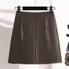 Saia preta popular de outono e inverno para mulheres, nova saia lápis de cintura alta emagrecedora de corte A, saia curta marrom de couro PU para mulheres de meia-idade e idosas