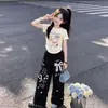 Traje Casual de Verano para Niñas 2026 Nuevo Estilo Dulce y Lindo Dibujos Animados Camiseta de Manga Corta Pantalones de Pierna Ancha con Encaje Set de Dos Piezas