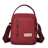 Bolso de hombro y cruzado para mujer de lona de nailon nuevo, bolso pequeño moderno y versátil, bolso para teléfono portátil multicapa, bolso de mano simple
