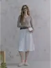Camiseta única y de nicho de punto de sarga gris con cuello en V y manga larga para mujer, top casual de otoño de alta gama ajustado con hombros normales