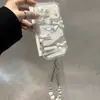 El lazo de encaje y la cadena de cuentas transforman instantáneamente tu iPhone 17 o iPhone 16 Pro Max en una funda de teléfono tipo caramelo de colores arcoíris.