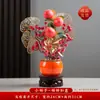 Peças decorativas com tema de caqui para 2026, criando uma atmosfera festiva para uma inauguração de casa, com flores artificiais criativas para exibição no rack da TV da sala