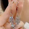 Moda Nueva Versátil Atmosférico Brillante Circonia Pendiente Clásico Largo Cara Redonda Adelgazante Temperamento Incrustado de Pedrería Pendientes Venta al por Mayor